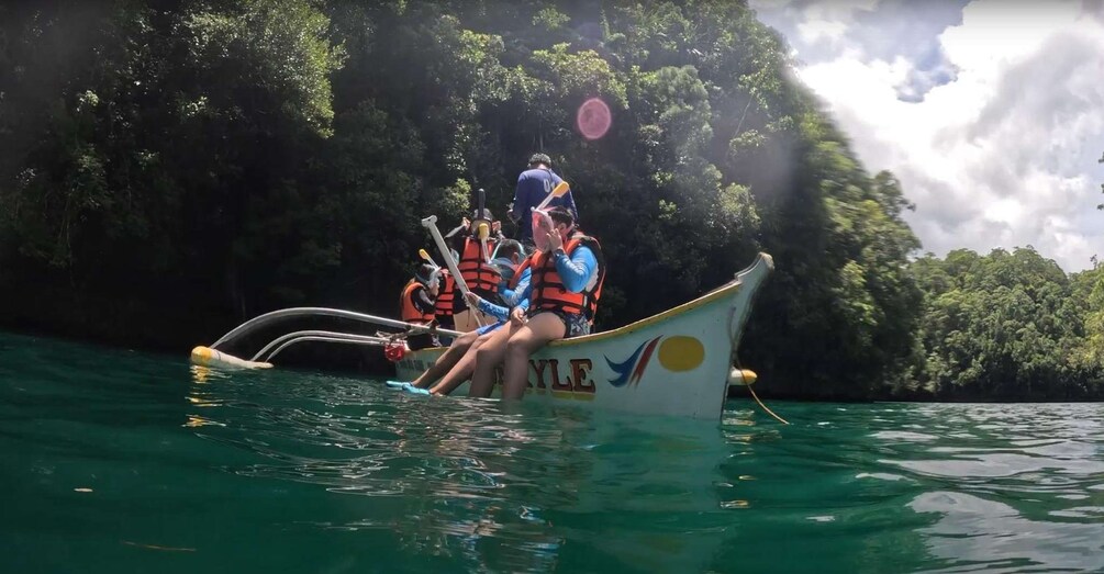 A group of people in a boat on a river surrounded by dense greenery. 4