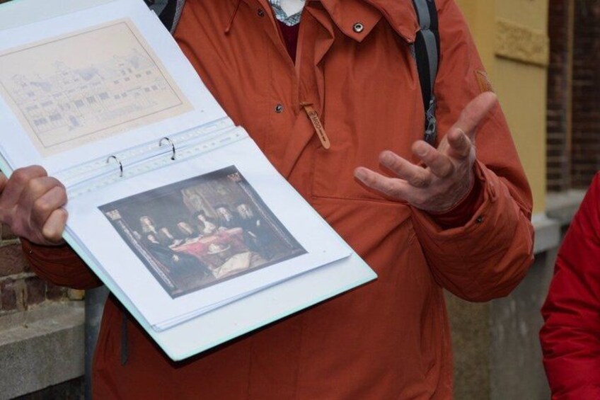A person holding a binder with a photograph and a page with text. 4