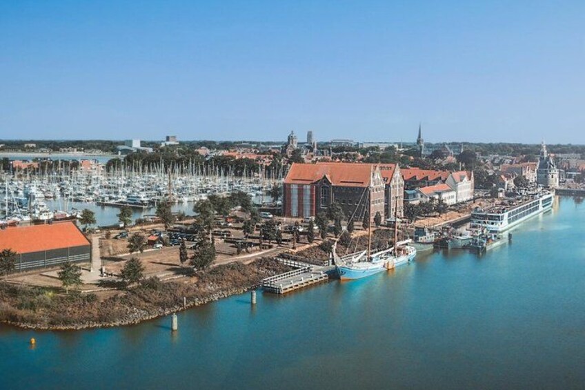 A harbor with a large ship, a church, and a marina with numerous boats. 5