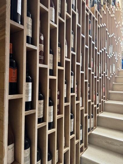 A wine cellar with wooden shelves and bottles of wine. 3