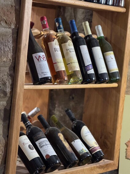 A wooden wine rack with various bottles of wine. 2