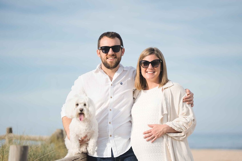 Ett par med en hund på en strand. 4