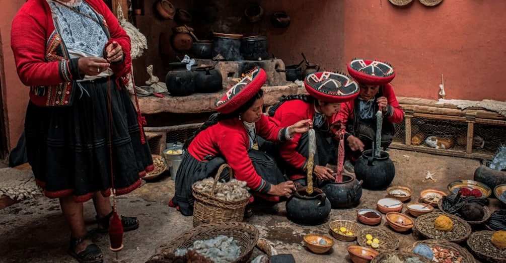 A traditional cooking scene with people preparing food in large pots. 2