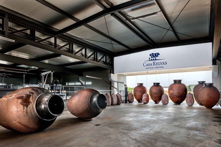 A warehouse interior with large metal pipes and ceramic pots. 2