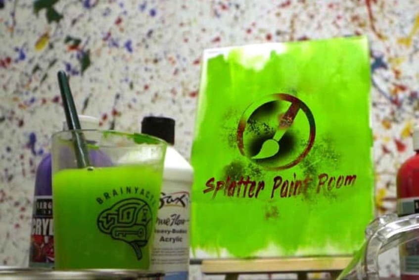 A green bag with 'Splatter Paint Room' text and a green drink with a straw. 2
