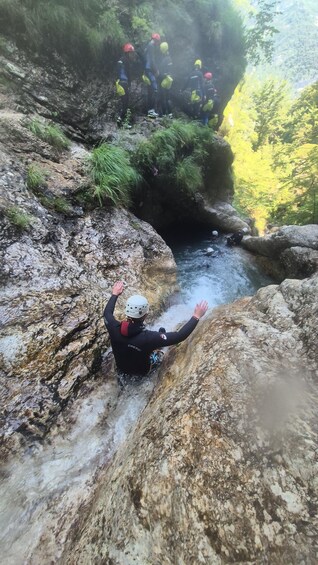 Eine Person seilt sich eine felsige Klippe hinab zu einem Fluss ab. 2