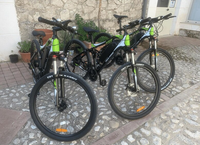 Två cyklar parkerade på en kullerstensbelagd yta framför en byggnad. 3