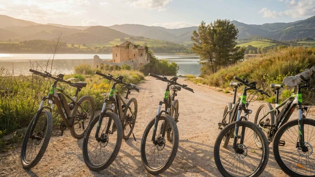 En grusväg med cyklar parkerade längs sidan, ett slott i bakgrunden och en sjö. 2