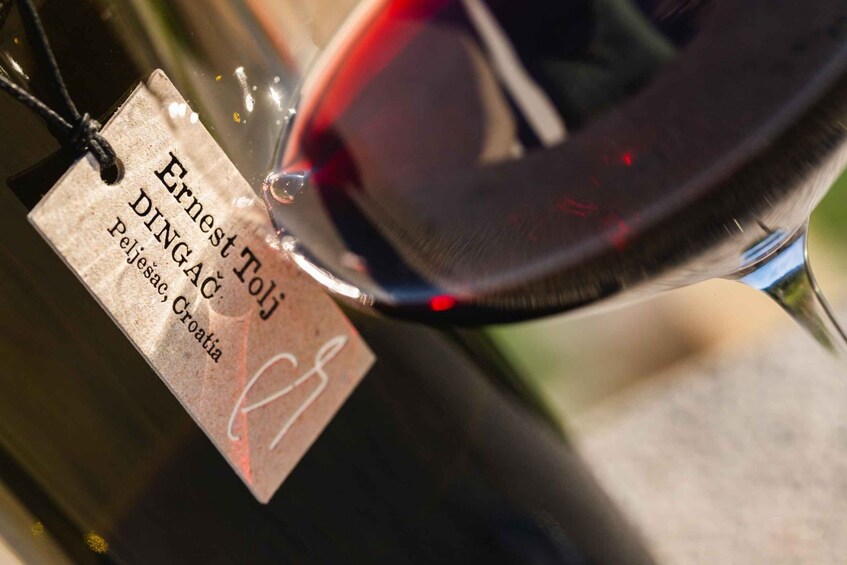 A wine bottle with a label that reads 'Ernest Toji DINGA, Peljesac, Croatia.' 4