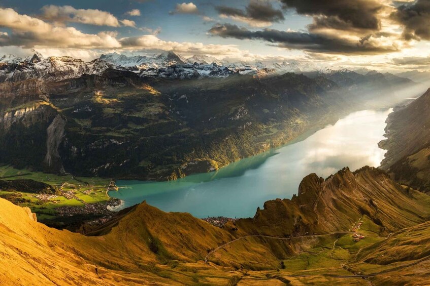 A mountainous landscape with a lake, a village, and snow-capped peaks. 3