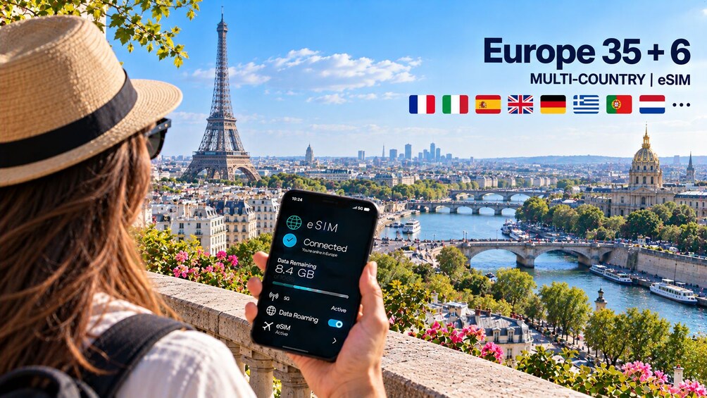 A person holding a smartphone with a view of the Eiffel Tower and Paris cityscape. 5