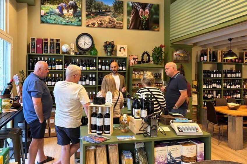 A wine shop interior with shelves of wine bottles, a clock, and a counter with wine glasses and corks. 5