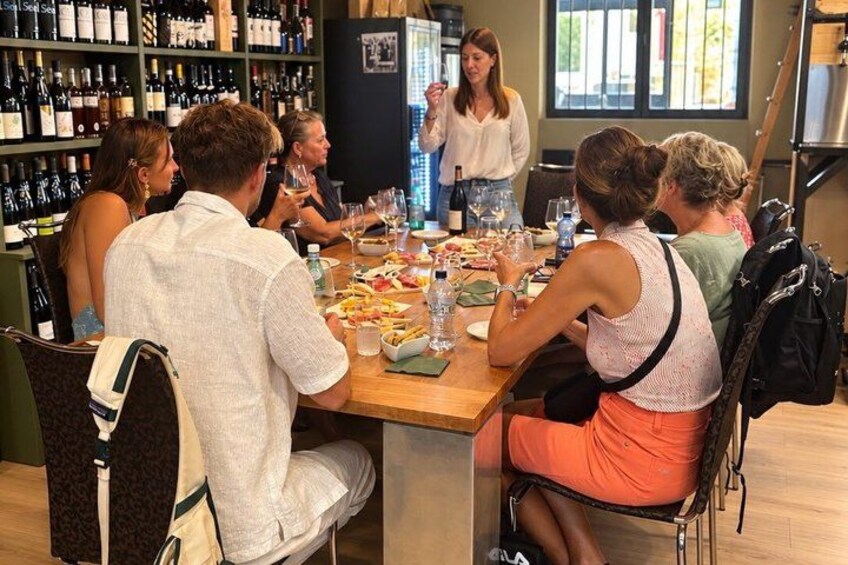 A group of people dining at a restaurant with a wine selection on display. 3