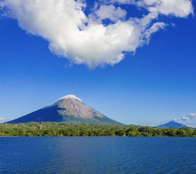 A volcano with a lake in the foreground and a clear sky. 3