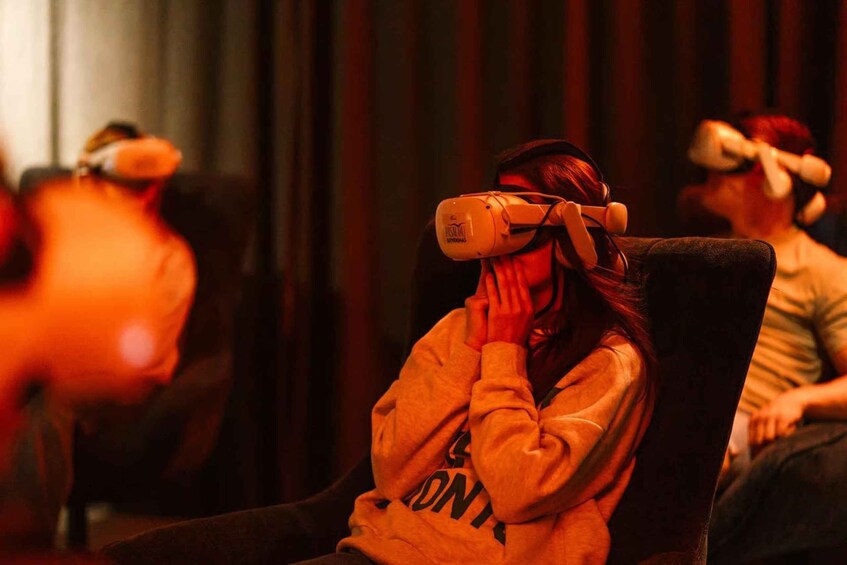 En person som bär ett VR-headset och sitter på en stol. 3
