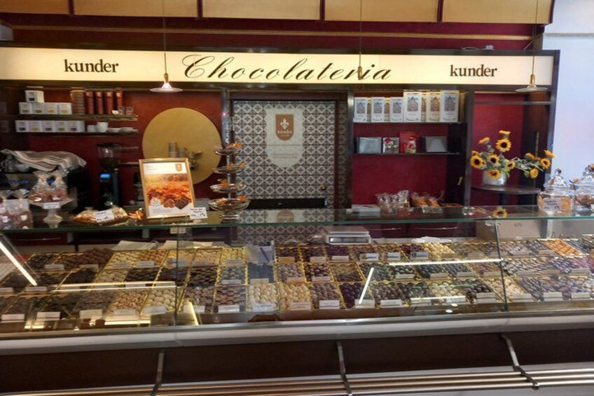 A chocolate shop with a display of assorted chocolates and a sign that reads 'kunder Chocolatiera.' 4