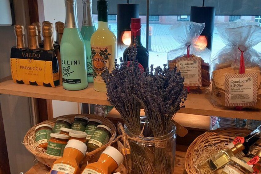 A variety of bottles and jars on shelves, including Valdo Prosecco and Bellini. 2
