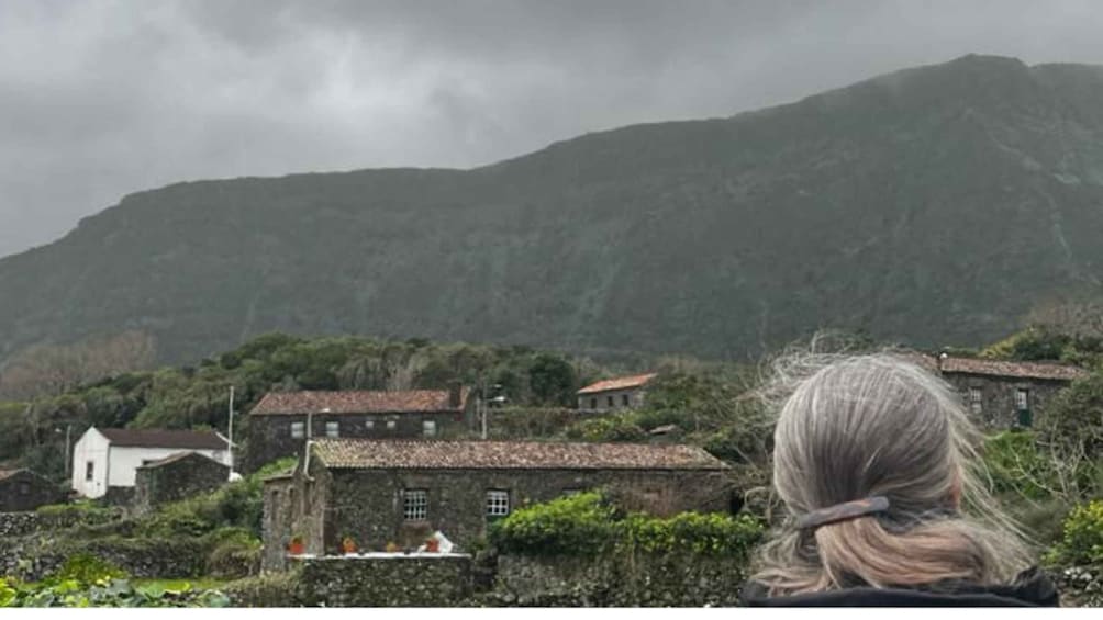 A mountainous landscape with stone buildings and a person with blonde hair. 2