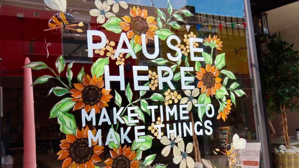 Une fenêtre ornée d’une fresque représentant des tournesols et portant l’inscription : « FAITES UNE PAUSE ICI ET PRENEZ LE TEMPS DE CRÉER ». 2