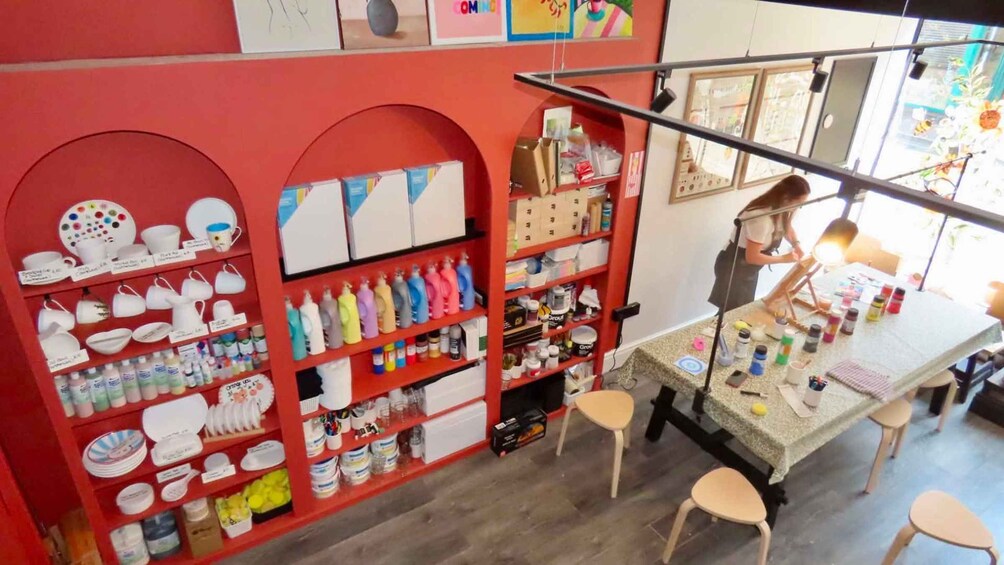 Un magasin de loisirs créatifs où l’on trouve des étagères remplies de poteries, de peintures et d’autres fournitures. 3
