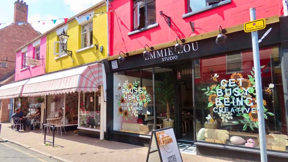 Une devanture de magasin avec une enseigne indiquant « MIMIE LOU STUDIO » et une vitrine avec l’inscription « LAISSEZ LIBRE COURS À VOTRE CRÉATIVITÉ ». 1
