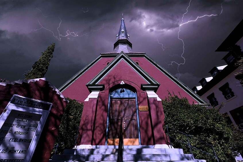 Une église avec un clocher et un éclair dans le ciel. 1