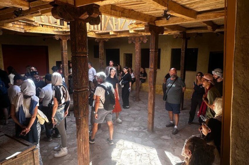 A group of people in a covered outdoor area with wooden beams and columns. 5