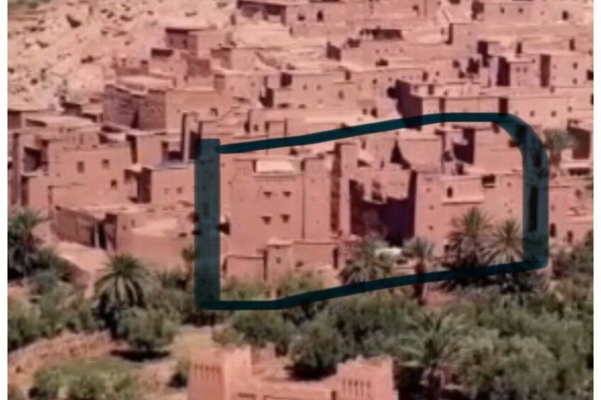 A densely packed village with traditional mud-brick houses and palm trees. 3