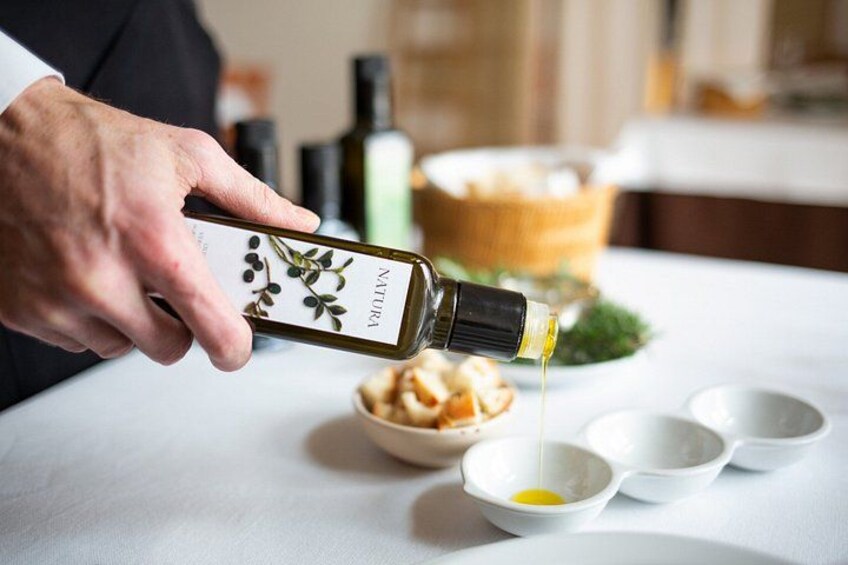 A person pouring olive oil into a bowl. 2