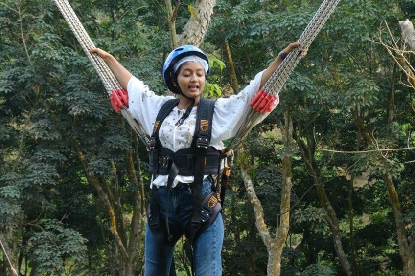 A person on a zip line in a forested area. 4