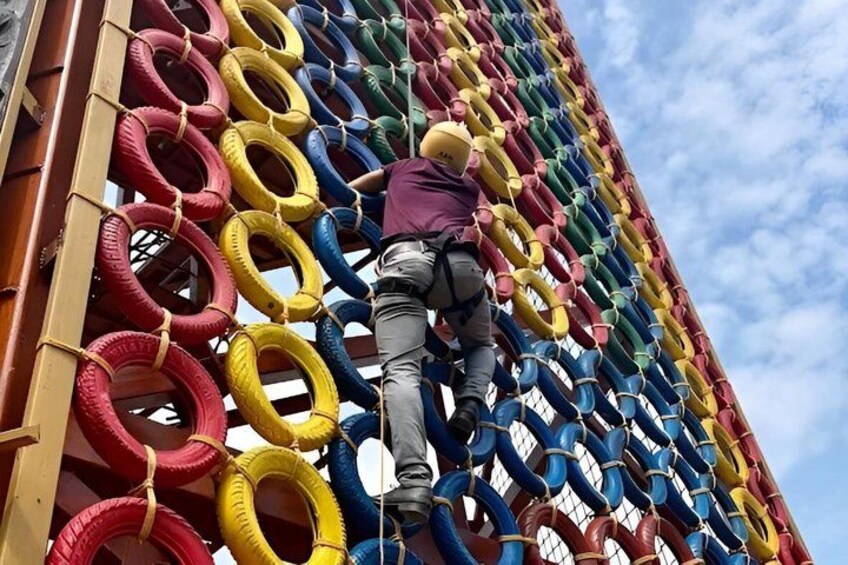A person climbing a wall made of interlocking tires. 5