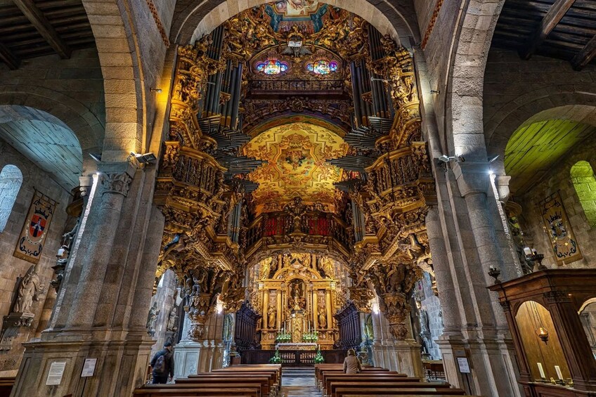 An ornate church interior with a high ceiling, golden decorations, and a central altar. 5