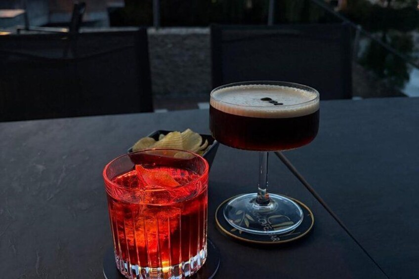 Two drinks on a table, one in a red glass and one in a stemmed glass. 5