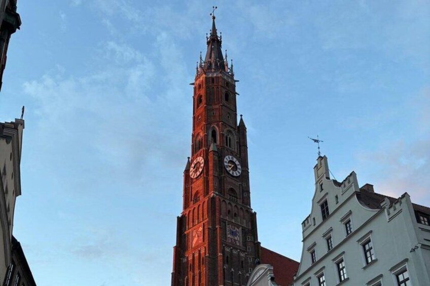 A tall clock tower with a spire, surrounded by buildings. 4