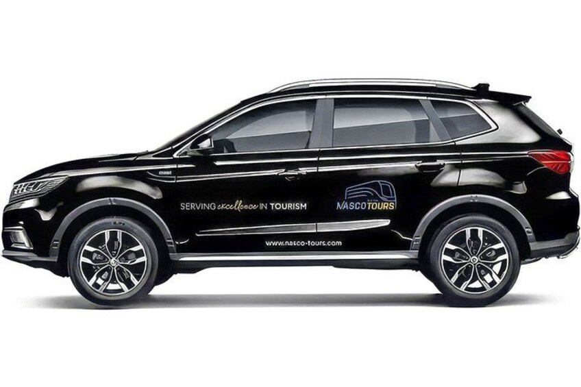A black SUV with 'SERVING excellence in tourism' and 'MASCO TOURS' branding on its side. 5