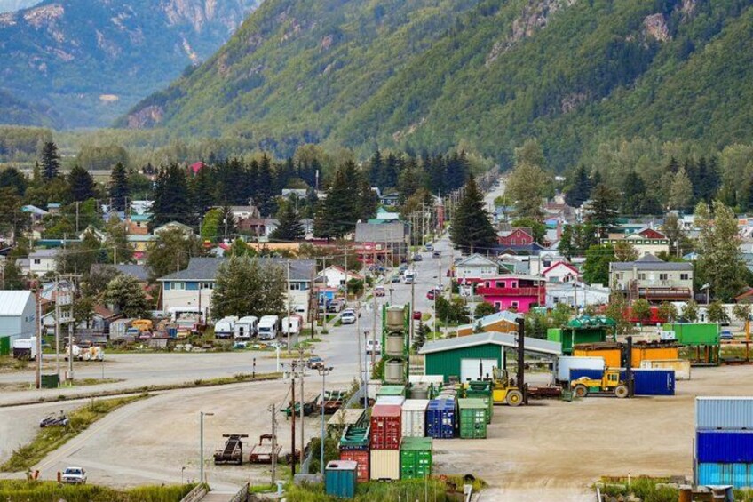 A small town with a main road, houses, and a mountainous backdrop. 3