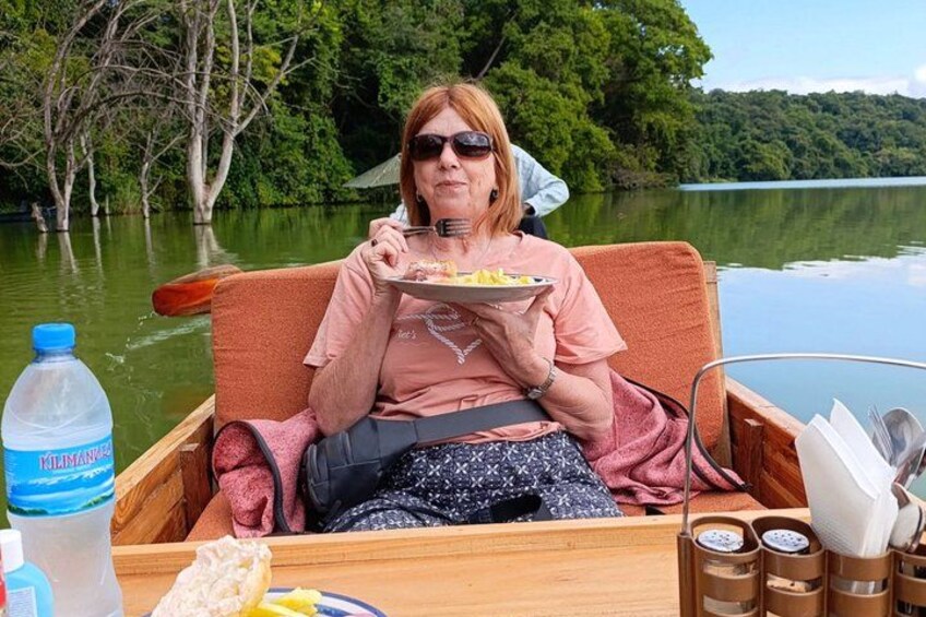 A person in a boat with a plate of food, a water bottle, and a map. 1