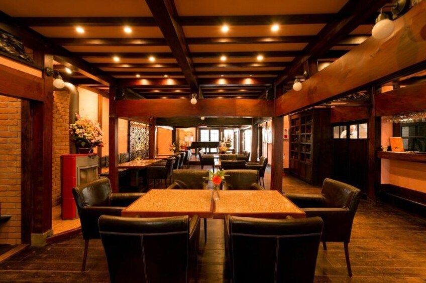 A restaurant interior with wooden beams, brick walls, and leather chairs. 4