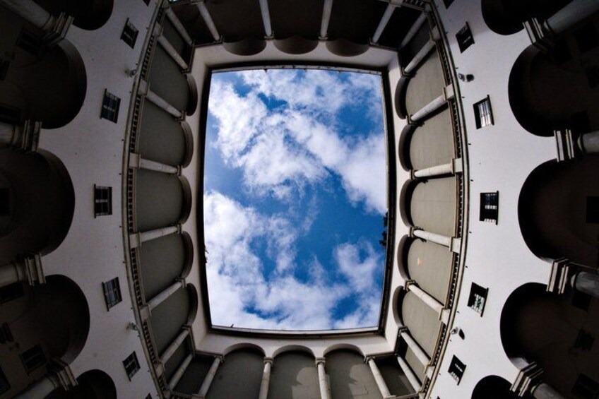 A circular architectural structure with a central skylight and surrounding seating. 3