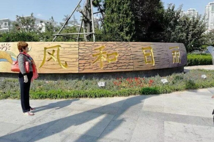 A woman standing in front of a stone monument with Chinese characters. 5