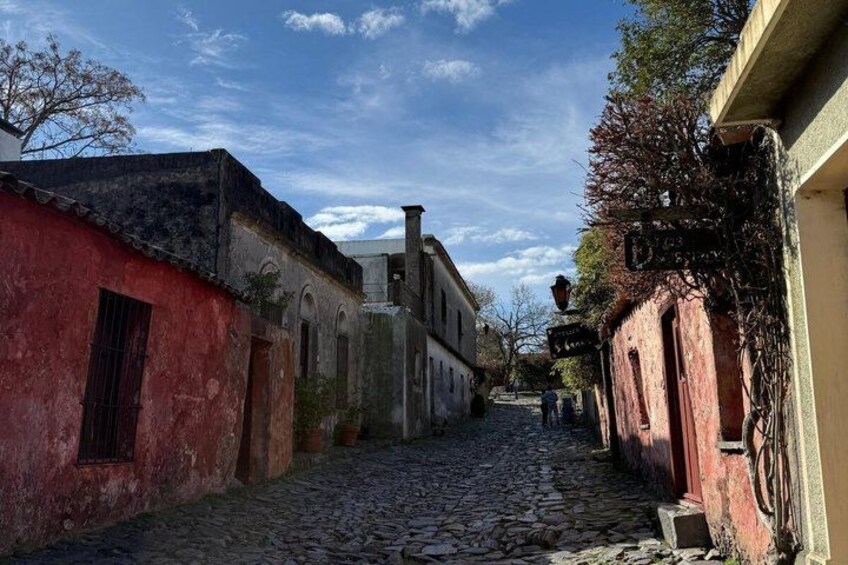 A cobblestone street flanked by historic buildings with arched windows and a clear blue sky. 5