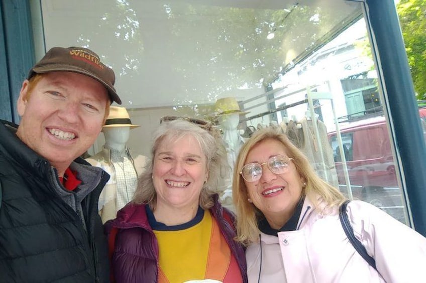 Three people in front of a glass building with a mannequin head. 2