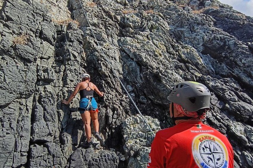 A person climbing a rocky mountain with a guide. 4