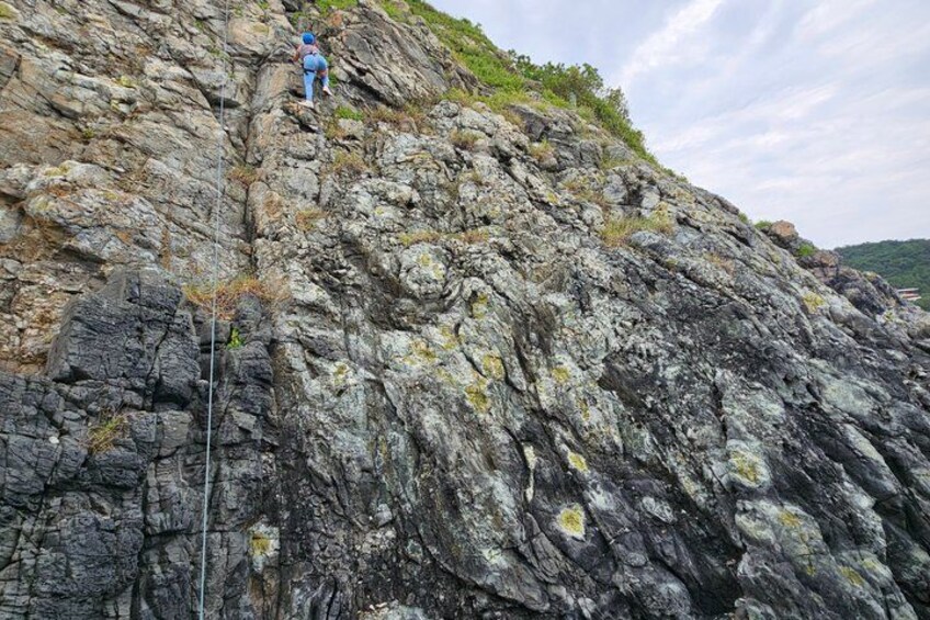 A rocky cliff with a person climbing. 1