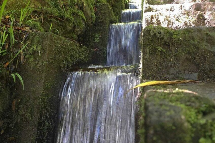 A multi-tiered waterfall cascading over moss-covered rocks. 3
