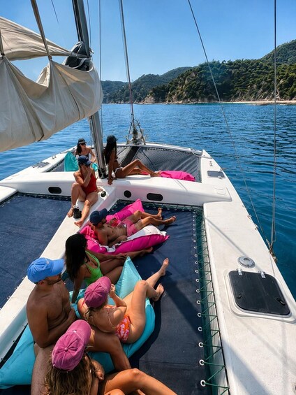A sailboat with people relaxing on deck cushions. 1
