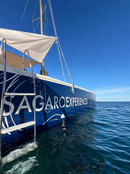 A sailboat with the text 'SAGARO EXPERIENCES' on its side, floating on calm blue waters. 2