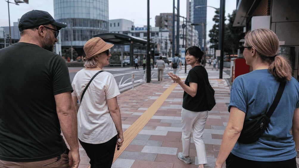 A group of people standing on a city sidewalk. 2