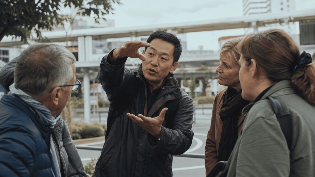 A group of people standing outdoors, engaged in a conversation. 5