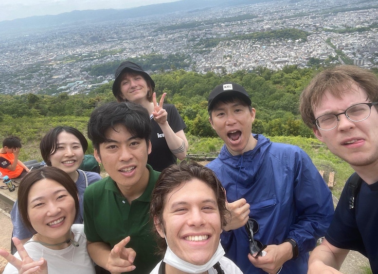 A group of people posing for a photo with a cityscape in the background. 1